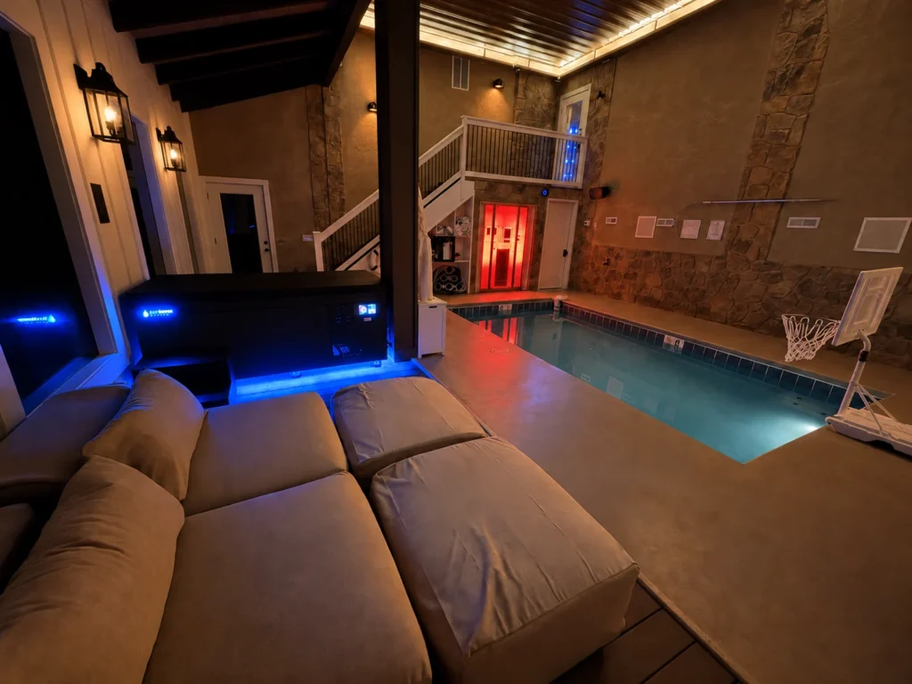 Blue lighting at the cold plunge and red lighting at the sauna beside the indoor pool.
