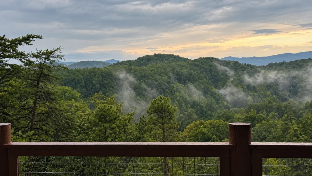 Wooded mountain ridges and drifting mist seen beyond the railing of Engle Haven’s deck.