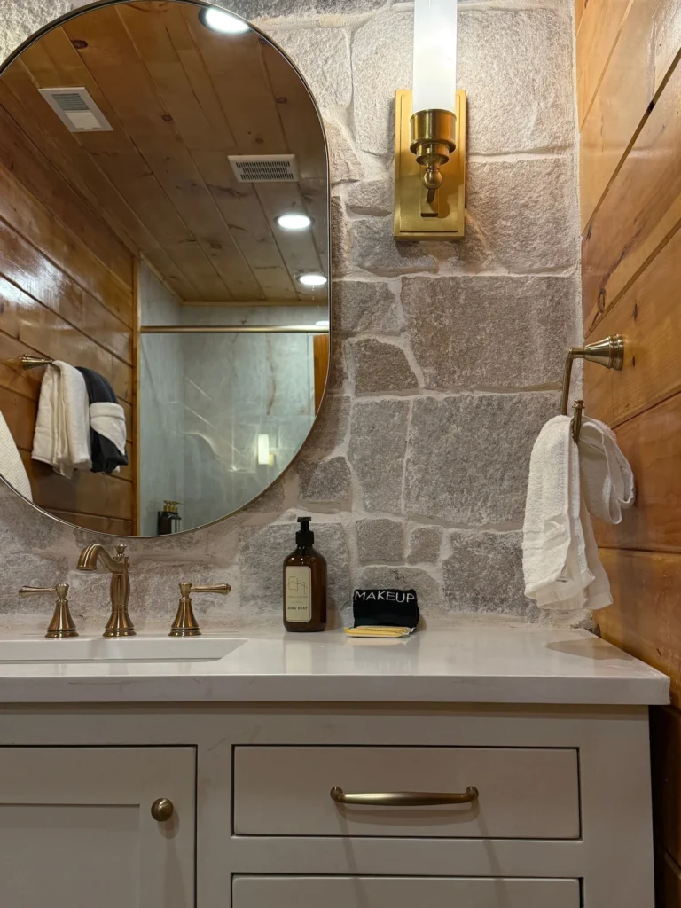A white vanity, oval mirror and tile shower in the bathroom.
