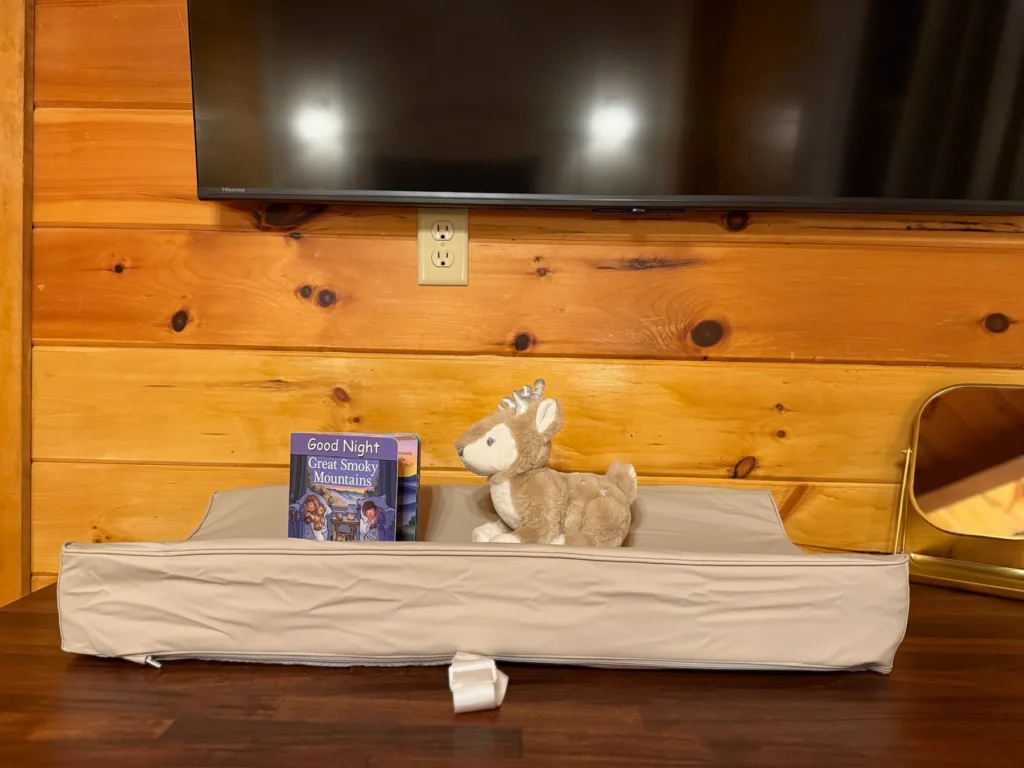 A changing pad with children’s books and a plush toy in the bedroom.