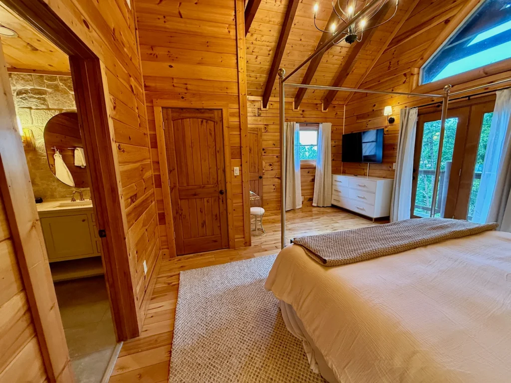 A view across the king bedroom toward its vanity, TV and deck doors.