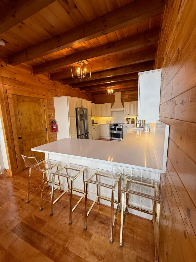 Counter stools line the breakfast bar beside the main kitchen.