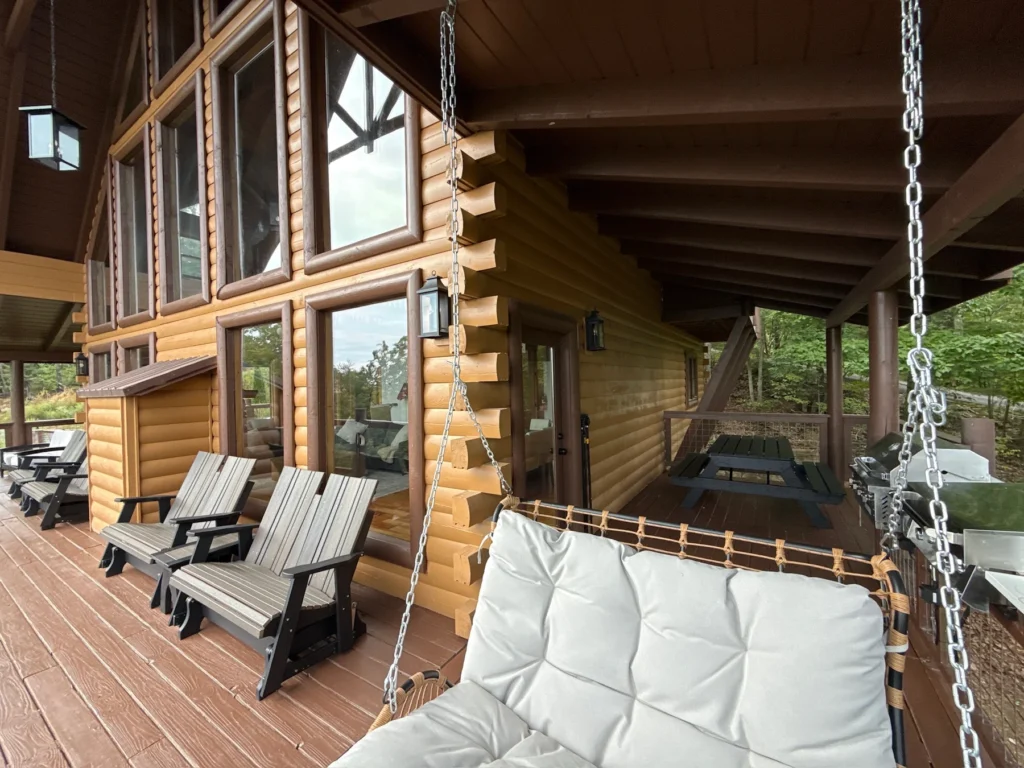 A hanging seat and rocking chairs line the deck beside the great-room windows.