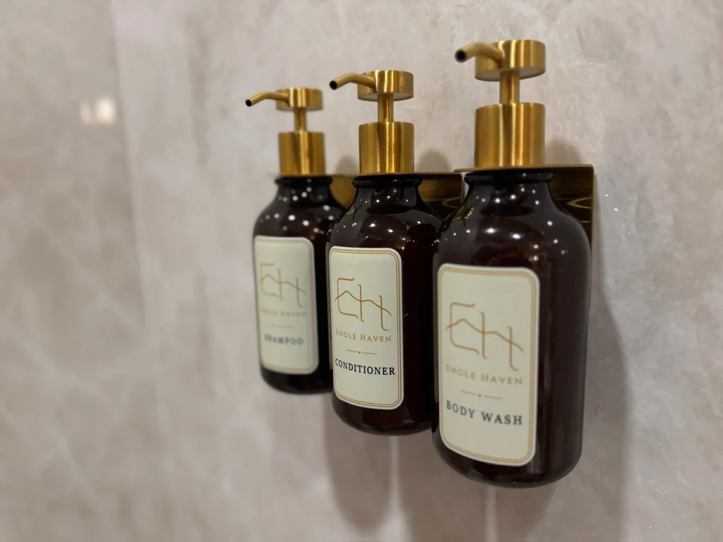 Engle Haven shampoo, conditioner and body wash mounted inside a tile shower.