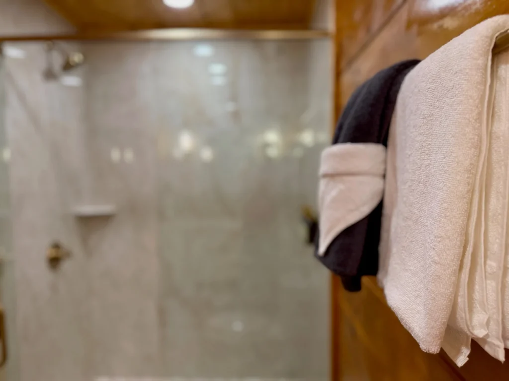 Bath and hand towels hang within reach of the tiled shower.