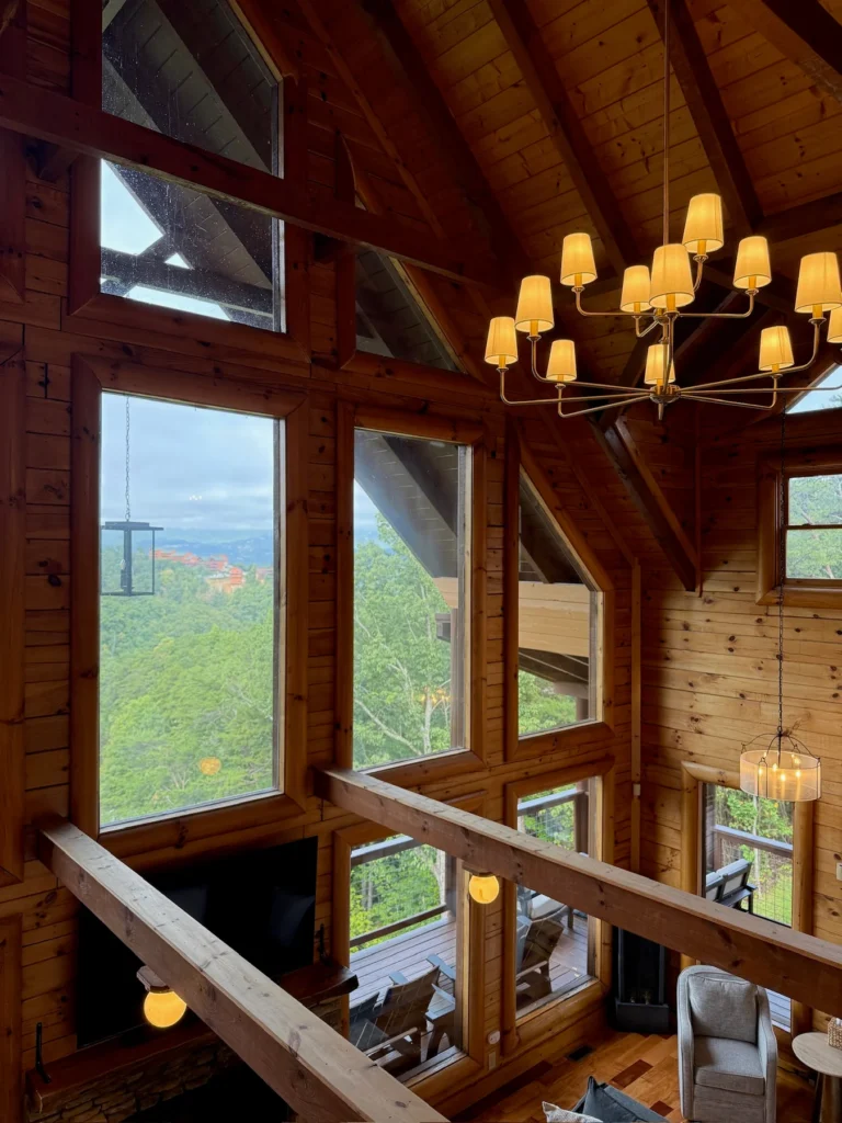 A view from the loft railing toward the vaulted great-room windows and chandelier.