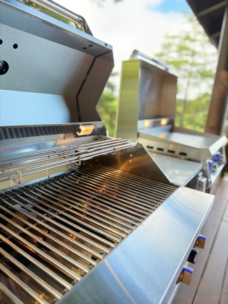 A close view of the open grill beside the griddle on the deck.