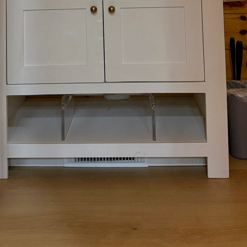 A clear step stool tucked beneath the bathroom vanity.
