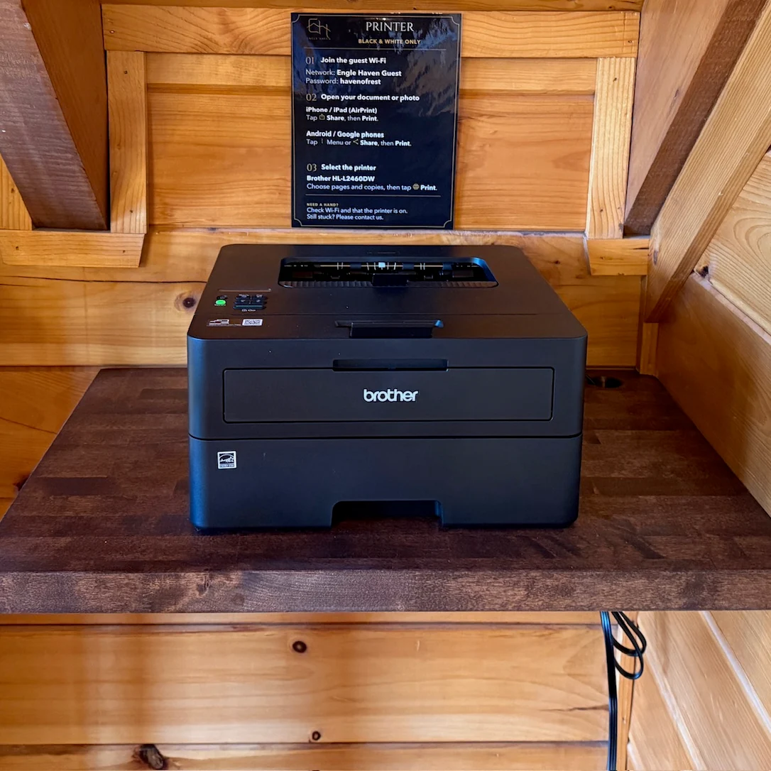 A guest printer on a wooden shelf in the cabin loft.