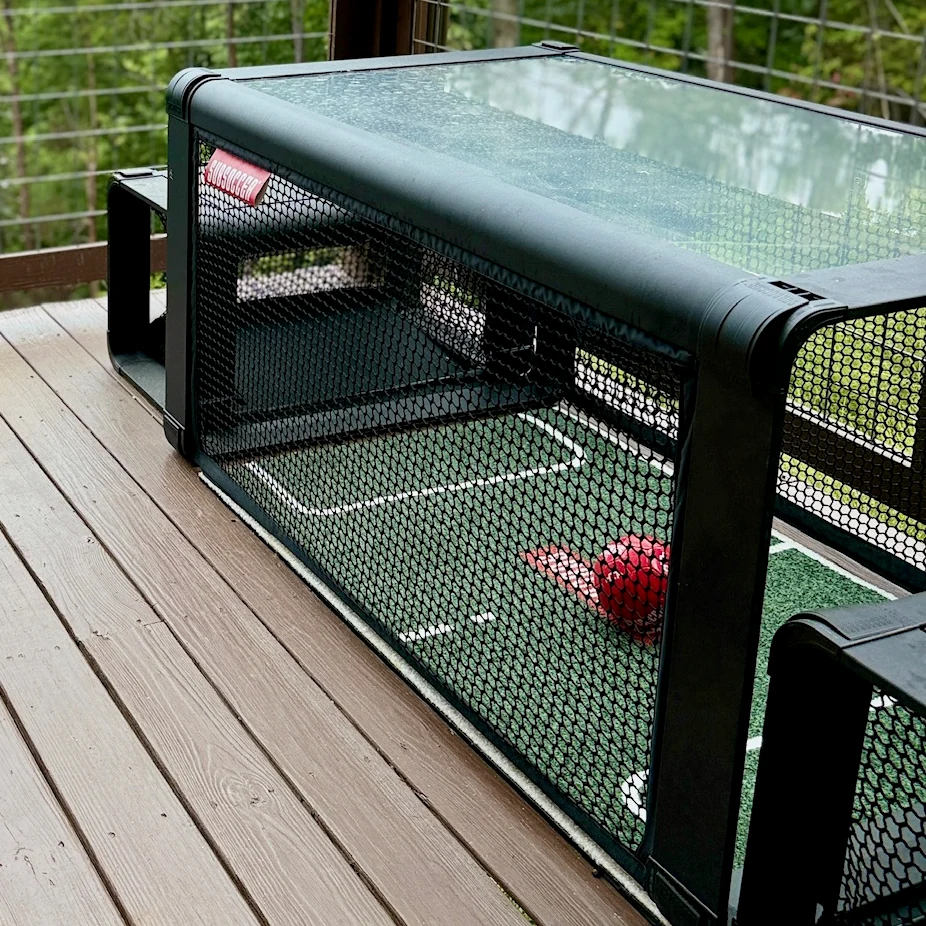 Close view of the Subsoccer table net, marked playing surface and red ball on the covered deck.
