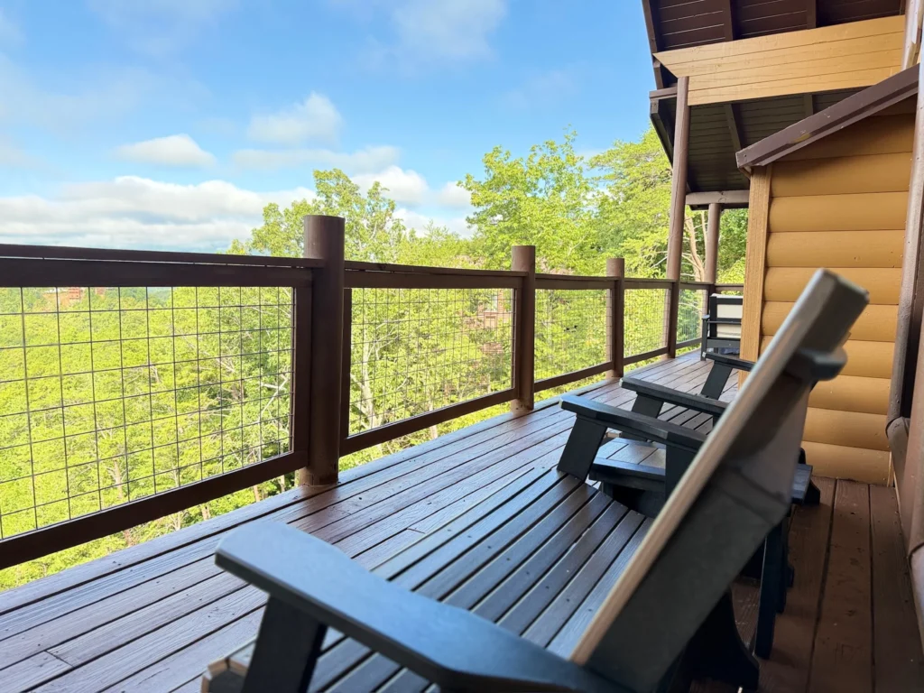 Dark rocking chairs on the covered deck facing the mountain view.