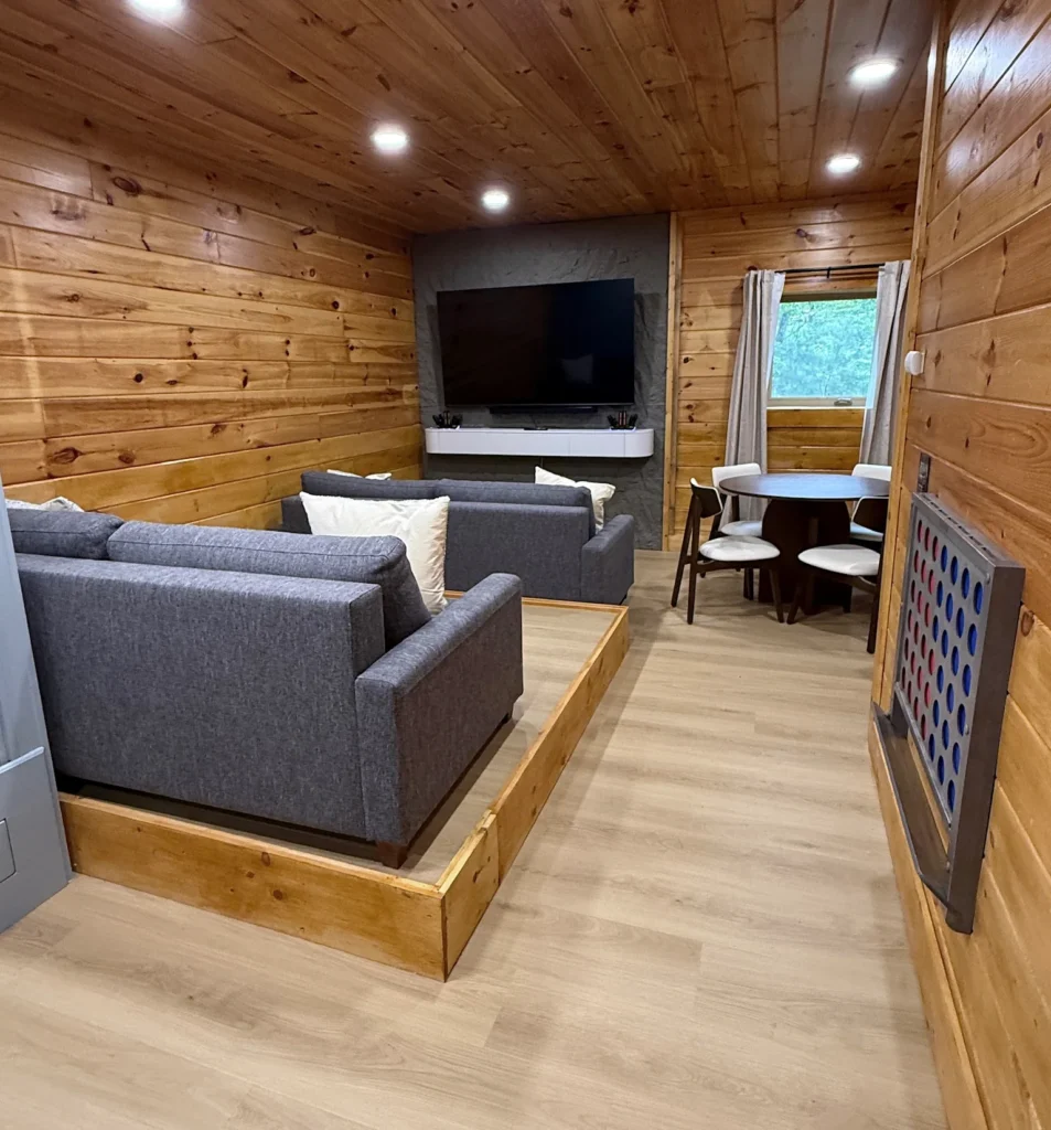 Television and tiered sofa seating beside a game table in the entertainment room.